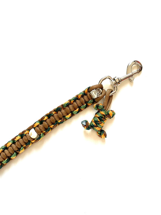 Laisse pour chien en paracorde solide et stylée. Couleurs : bronze, orange et vert, gros plan sur le mousqueton